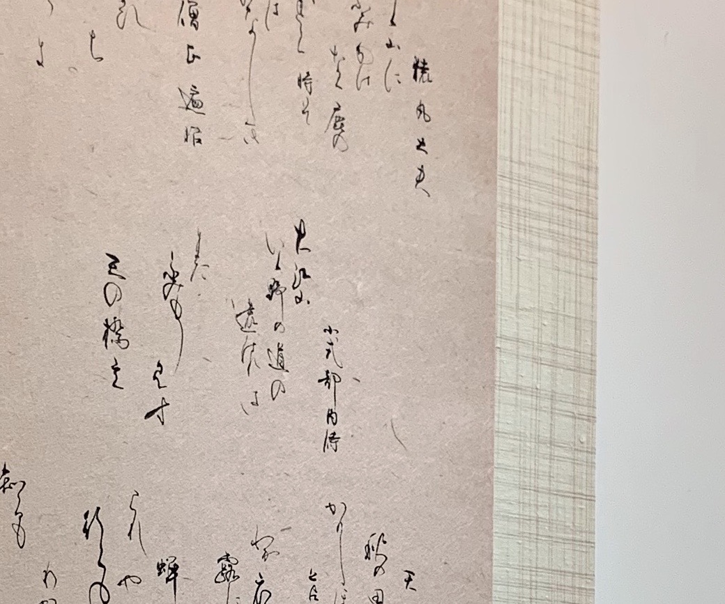 書作品の細部。墨の線、紙の繊維と表具の境界